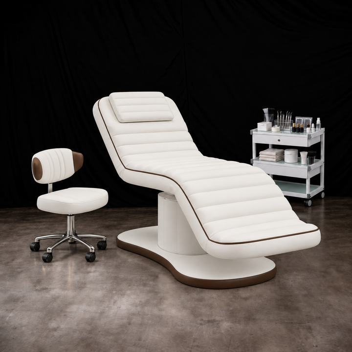 White electric facial bed with brown trim and matching rolling esthetician stool